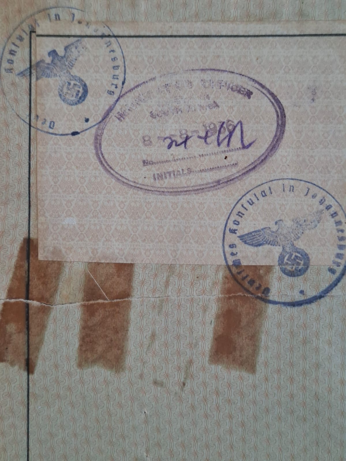 A stamped page of the 1939 passport: two German Consulate Johannesburg stamps bearing an eagle and swastika, and an oval South African immigration officer's stamp dated the eighth of the eighth, the year indistinct